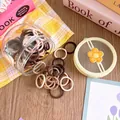 Macro detail of high-elasticity hair ties in brown tones with flower lid storage jar - Smooth Milk Coffee Style