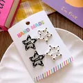 Detailed view of four star-shaped hair clips with polka dots on a handmade display card - Five-pointed Star Polka Dot