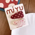 Dettaglio di fermagli per capelli in tessuto a fiori e pois su confezione fatta a mano - Stile Floreale a Pois / Rosso a Pois