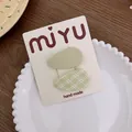 Juego de dos horquillas verdes de tela con diseño de cuadros sobre cartón - Juego Verde