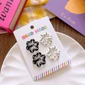 Close-up of four floral hair clips with polka dots on a handmade cardboard display - Flower Polka Dot
