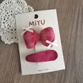 Detalle del set de horquilla con lazo de cuadros rosa y clip de tela sobre tarjeta - Grupo Lazo Relleno / Juego Rosa