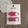 Dettaglio di due fermagli per capelli in tessuto scozzese rosa con bottoni su carta - Stile Molletta Base / Set Rosa