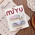 Detail of silver bow and star hair clips set on display card with a rustic background - Star Hair Clip Set