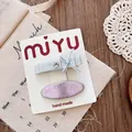 Detail of handmade silver bow and purple glitter hair clips on branded card - Flat Bow Hair Clip Set