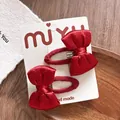 Nahaufnahme von zwei roten Satin-Haarspangen mit Karomuster und handgemachter Karte - Einfarbige Schleife Snap-Clip