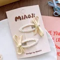 Detalle de pinzas para el cabello con lazos de tela en una tarjeta decorativa - Pinza para el cabello / Amarillo
