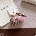 Detailed macro of fabric heart charms on a hair tie in pink and brown checkered patterns - Heart Hair Ties