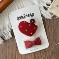 Gros plan de barrettes faites main avec cœur rouge et nœud avec dentelle sur carte - Pince BB Tricotée Coeur