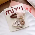 Close-up of floral fabric hair clip and pink felt star set on branded card packaging - Star Combination Style
