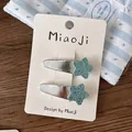 Detailed macro view of two silver hair clips featuring blue glitter star decorations - Star BB Hair Clips