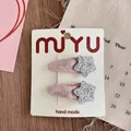 Detail of two handmade velvet sequin star hair clips for girls on a white card display - Velvet Wrapped BB Clip / Silver Star
