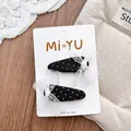 Detailed close-up of sweet lace and polka dot hair clips on a white display card - Black Polka Dot Bow Style