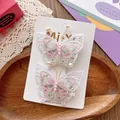 Detailed view of hand-embroidered butterfly hair clips with pearls on a wooden tray - Purple Butterfly