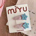 Detail of two handmade velvet hair clips with blue glitter star on white display card - Velvet Wrapped BB Clip / Blue Star
