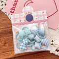 Détail de mini chouchous pour enfants avec motifs floraux bleus et formes d'étoiles - Série Bleue