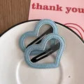 Détail de deux barrettes à cheveux en denim bleu en forme de cœur avec coutures apparentes - Denim Bleu Clair Cœur