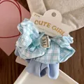 Detail of light blue plaid fabric scrunchie with handmade label and ribbon bow - Blue Plaid