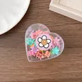 Detailweergave van mini bloem haarspeldjes in een hartvormige transparante opbergdoos - Bloemvorm (250439)