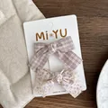 Detail view of plaid and floral fabric bow hair clips on a white display card - Light Purple Bow