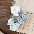 Detail of plaid and floral bow hair ties with elastic bands on a branded display card - Blue Printed And Plaid Styles