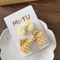 Dettaglio di fermagli per capelli in tessuto jacquard giallo e a quadretti su vassoio - 4-piccola Clip A Fiocco