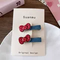 Vue détaillée de pinces à cheveux à nœud rouge à pois sur tissu denim bleu sur carte - Pince Nœud Pois Rouges