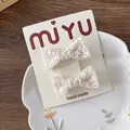 Primer plano de lazos de encaje beige para el pelo con patrones calados en tarjeta - Estilo de Lazo de Encaje Beige / Clip de Encaje