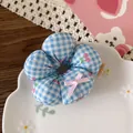 Close-up of a floral hair scrunchie with blue checkers and cherry print in a ceramic dish - 4-Blue Plaid Cherry Style