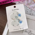 Detailansicht der BB-Haarspangen aus Blumenstoff mit Knopfakzenten auf Displaykarte - Ovaler Knopf Stil / Blaues Blumenmuster