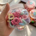Detail of colorful elastic towel hair ties for kids in a transparent storage jar - Multicolor