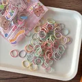Detail of colorful macaron elastic hair bands in a cute rabbit bear patterned pouch - Candy Smooth Style
