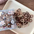 Spiral elastic hair ties in brown and cream earth tones on a white tray - Coffee Series Spiral Style