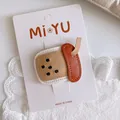 Detail of a milk tea cup shaped leather hair clip with stitching on a lace background - Milk Tea