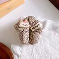 Detailed close-up of brown floral scrunchie with an embroidered rabbit and fabric label - Floral Rabbit