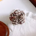 Detailed view of checkered scrunchie featuring a brown embroidered bear and fabric label - Gingham Bear