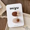 Detailansicht von zwei Mini-Haarspangen aus Leinen mit Schleifen auf einer Karte - 5-Kaffee Gruppe