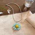 Close-up detail of a colorful beaded necklace with a large blue daisy flower pendant - Blue Multi-Color