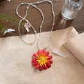 Detailed macro shot of a vibrant red flower pendant on a white beaded pearl necklace. - Red - Transparent