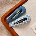 Detailaufnahme von Haarspangen aus Denim und blauem Karostoff auf rustikalem Hintergrund - Wassertropfen Gruppe / Blau-Serie