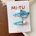 Detail shot of embroidered blue whale hair clip and pink bead clip on a display card - Blue Whale
