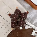 Detail van bruine bloemen haarelastiek in stervorm met zachte pluche ballen en katoen - Koffie Ster Stijl