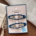 Dettaglio di due fermagli per capelli BB blu a pois su carta decorativa confezionata - Blu