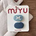 Detail von handgefertigten ovalen karierten Haarspangen für Kinder mit Schleifen - 4-Blau Gruppe