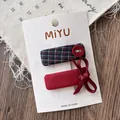 Dettaglio di fiocco rosso e fermaglio a quadri blu navy su cartoncino per capelli - Quadretti Quadrati