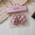 Detailweergave van de roze hart- en sterhaarstrikjes in transparante verpakking met kaart - Roze Set