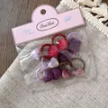Detail of assorted velvet and plaid fabric hair ties for girls in transparent packaging - Purple Gingham Heart