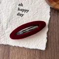 Makro-Detail der weinroten Samt-Haarklammer mit hohlem ovalem Design und Textur - Samt Rot Oval Stil