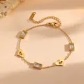 Close-up of gold stainless steel bracelet with hollow hearts and rectangular gems - Hollow Heart White Rhinestone Style (L713)