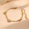 Gedetailleerd beeld van goudkleurige roestvrijstalen dubbellaagse armband met rechthoekige stenen - Dubbellaagse Witte Strass Kraal Stijl (L712)